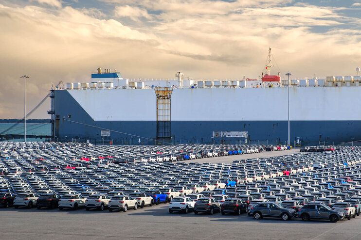 Auto-Transport-Schiff (RoRo) im Hafen vor Anker mit geparkten Fahrzeugen.