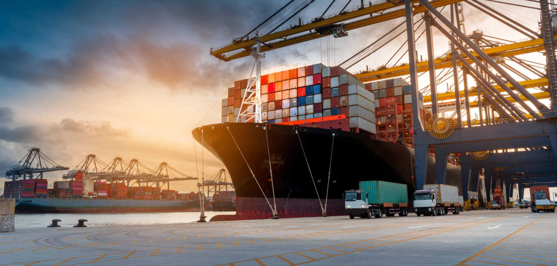 Kran lädt Container von LKW auf Containerschiff im Seehafen
